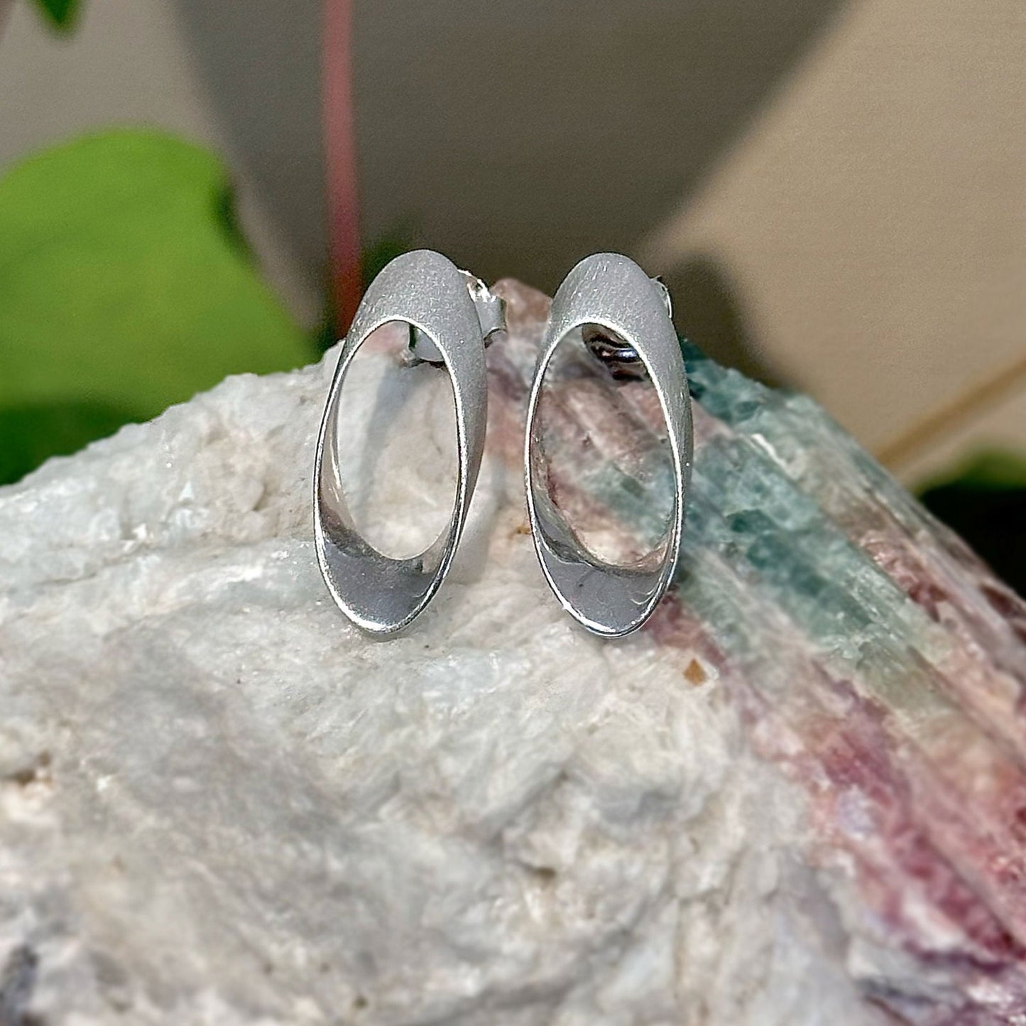 Photo of "Nova" Post Earring in a decorative scene, designed by -, available at Plumb Gold & Plumb Silver