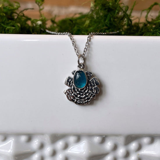 Photo of “Oak” Apatite Necklace in a decorative scene, designed by , available at Plumb Gold & Plumb Silver