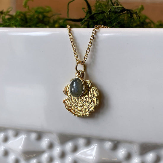 Photo of “Oak” Labradorite Necklace in a decorative scene, designed by , available at Plumb Gold & Plumb Silver