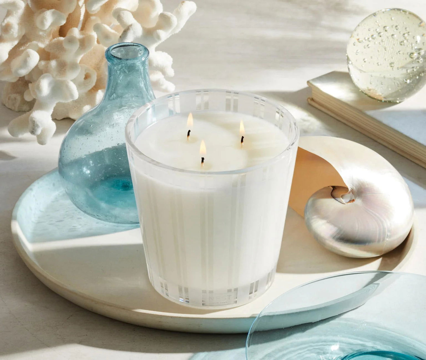Photo of Ocean Mist & Sea Salt Candle in a decorative scene, designed by , available at Plumb Gold & Plumb Silver