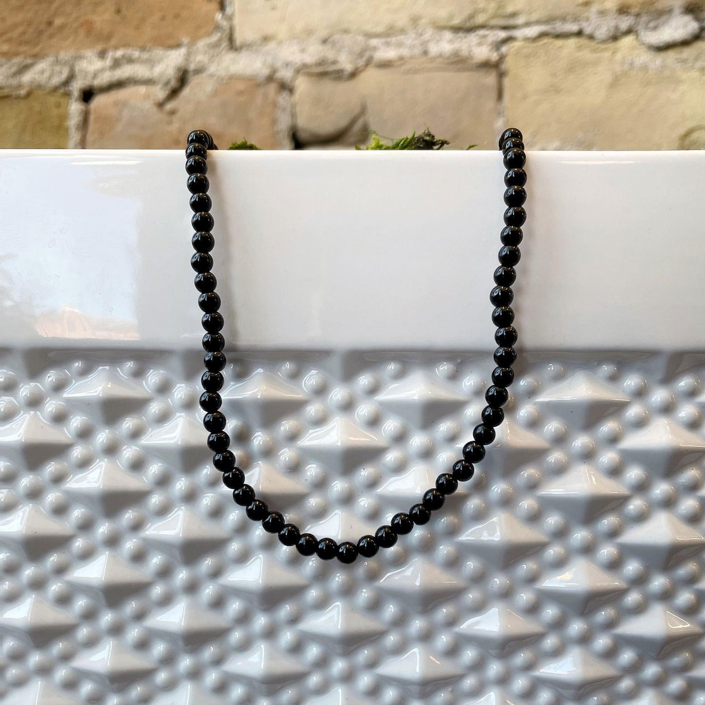 Photo of Onyx Necklace in a decorative scene, designed by , available at Plumb Gold & Plumb Silver