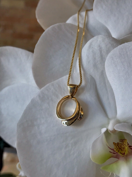 Photo of Open Swirl Pendant in a decorative scene, designed by , available at Plumb Gold & Plumb Silver