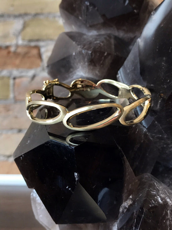 Photo of Ovals Bangle in a decorative scene, designed by , available at Plumb Gold & Plumb Silver