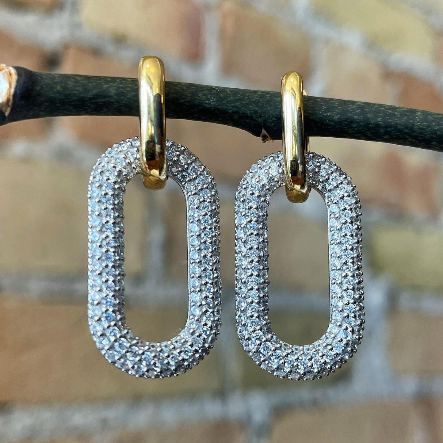 Photo of Paper Clip Cubic Zirconia Earrings in a decorative scene, designed by , available at Plumb Gold & Plumb Silver
