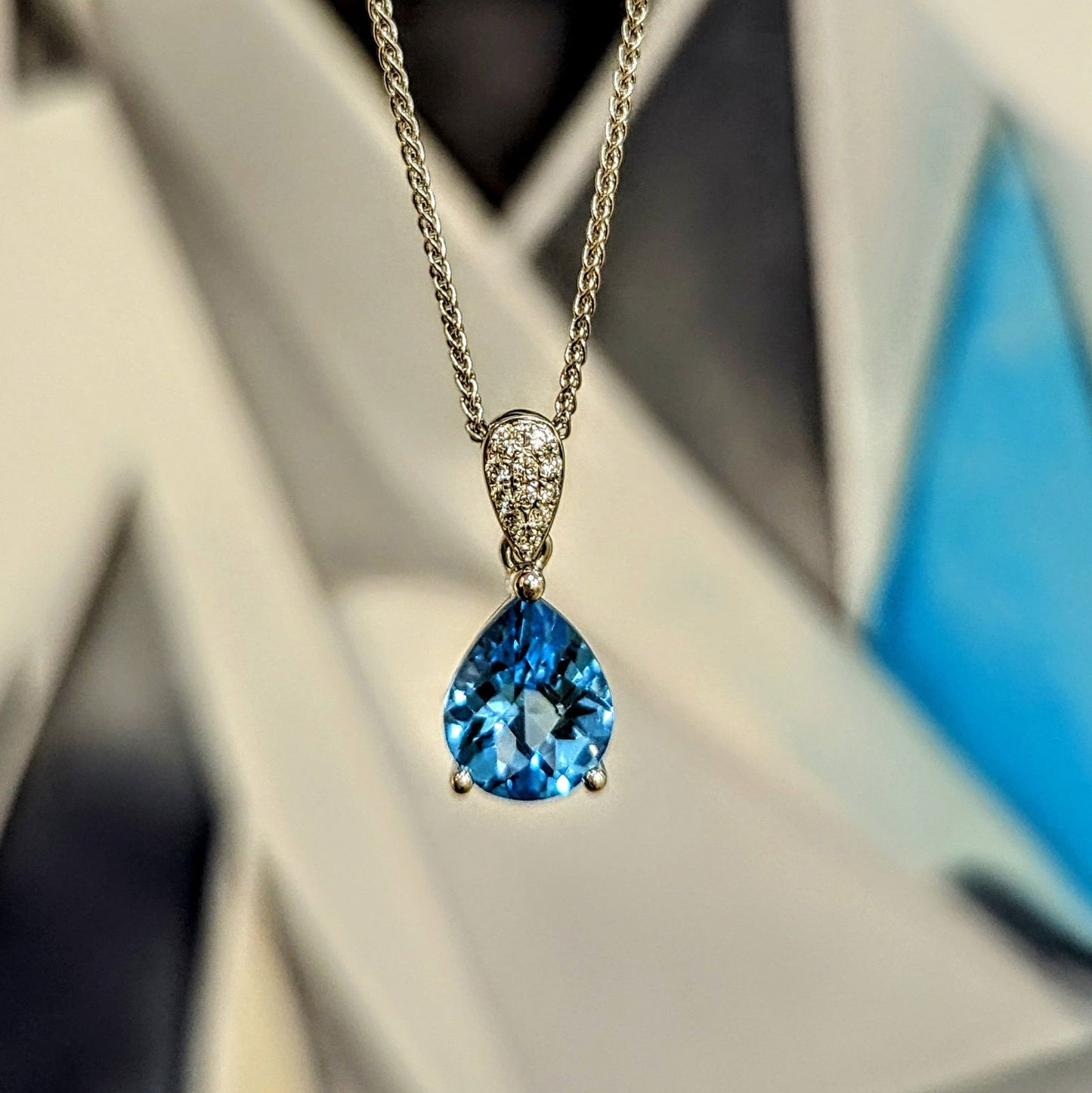 Photo of Pear Topaz and Diamond Pendant in a decorative scene, designed by , available at Plumb Gold & Plumb Silver
