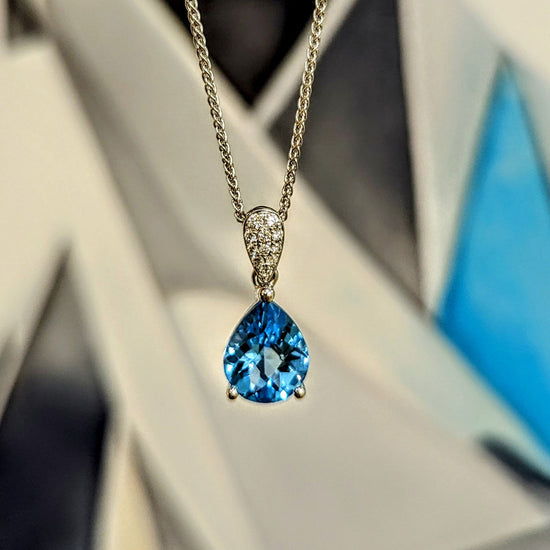 Photo of Pear Topaz and Diamond Pendant in a decorative scene, designed by , available at Plumb Gold & Plumb Silver