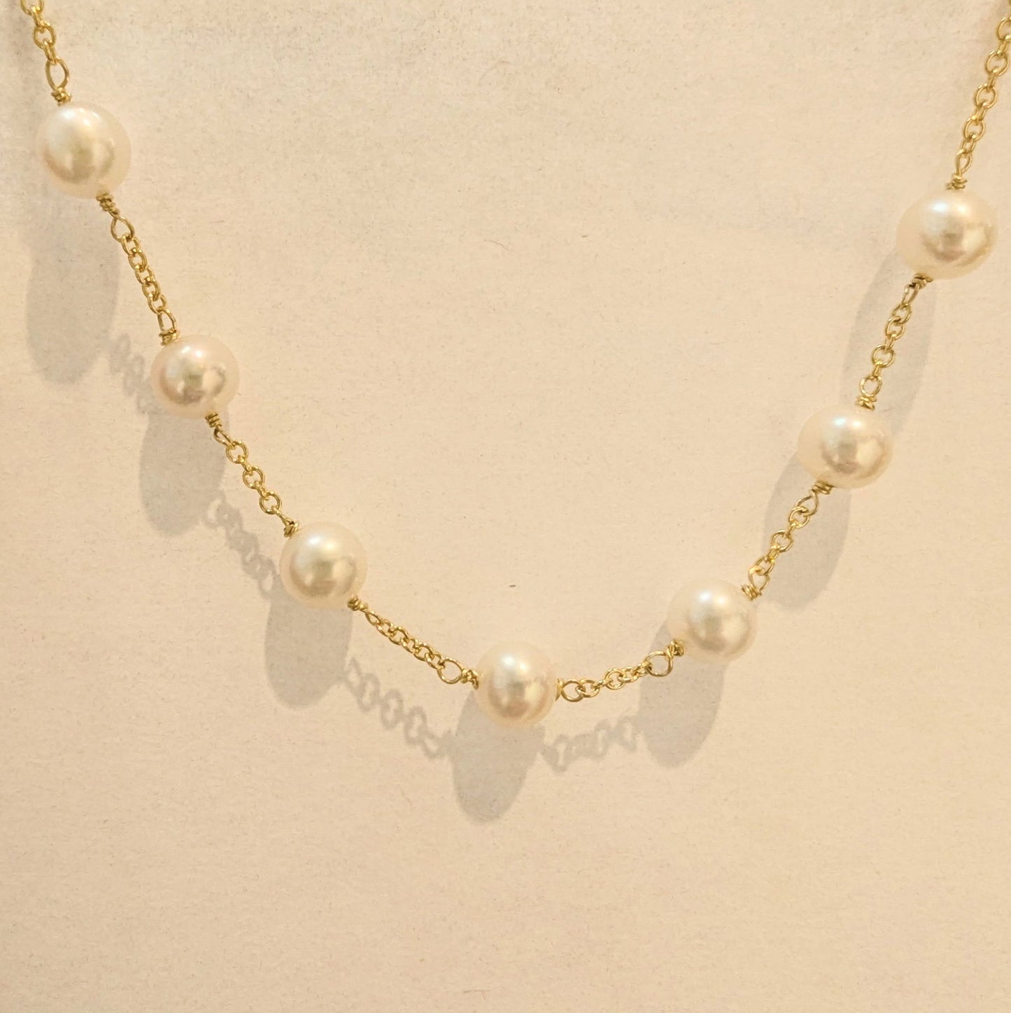 Photo of Pearl Station Necklace in a decorative scene, designed by , available at Plumb Gold & Plumb Silver