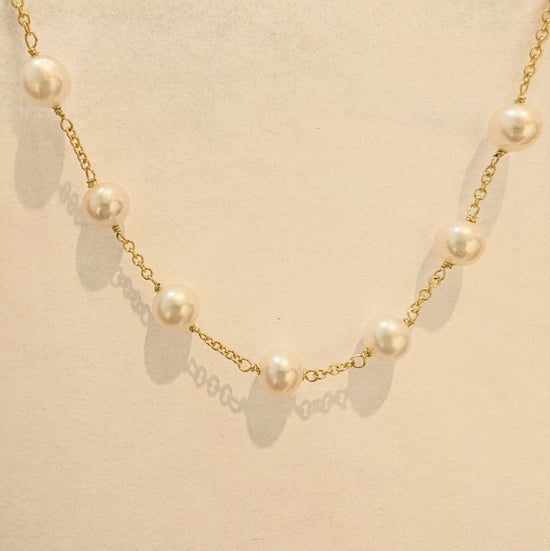 Photo of Pearl Station Necklace in a decorative scene, designed by , available at Plumb Gold & Plumb Silver