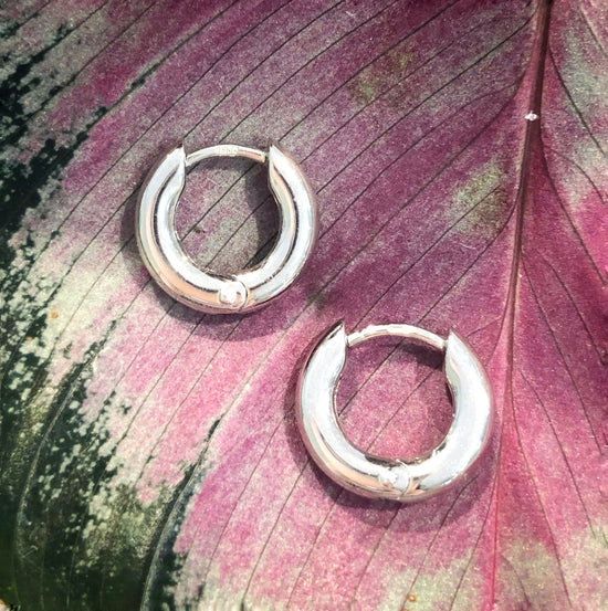 Photo of Petite Classic Hoops in a decorative scene, designed by , available at Plumb Gold & Plumb Silver