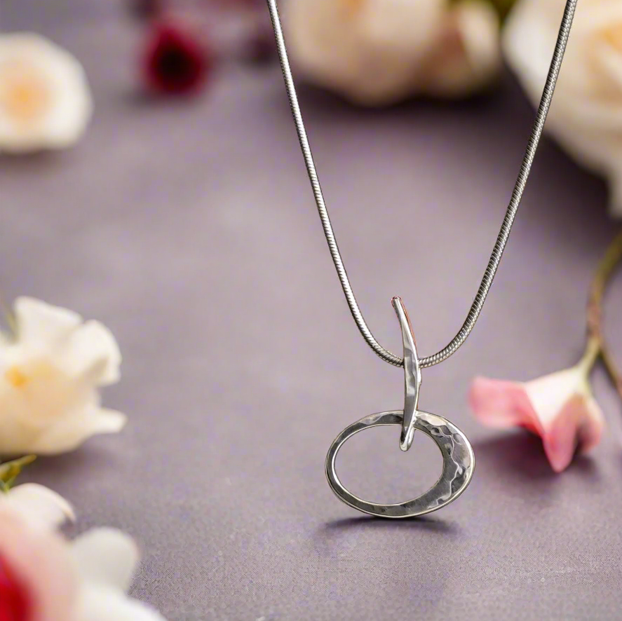 Photo of "Petite Elliptical" Necklace in a decorative scene, designed by , available at Plumb Gold & Plumb Silver