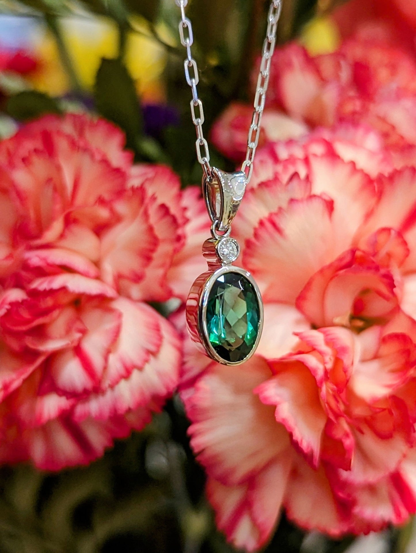 Photo of Petite Tourmaline Pendant in a decorative scene, designed by , available at Plumb Gold & Plumb Silver