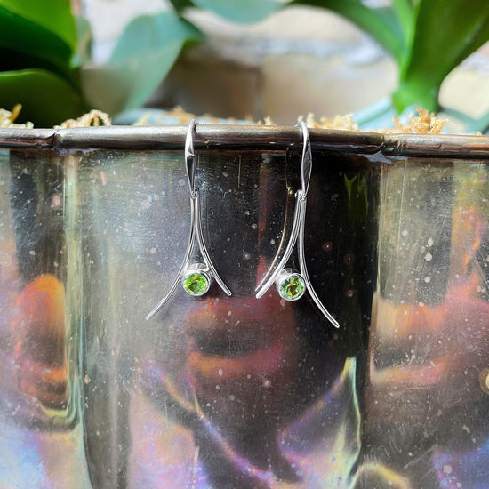 Photo of "Pinnacle" Dangle Earrings in a decorative scene, designed by , available at Plumb Gold & Plumb Silver