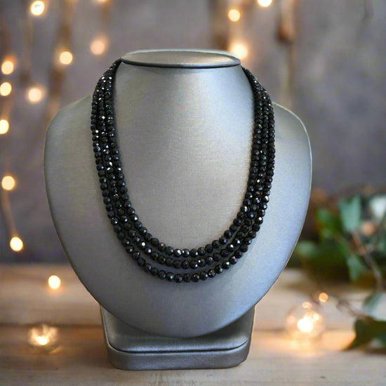 Photo of Plumb Silver Original 3-Strand Black Spinel Necklace in a decorative scene, designed by , available at Plumb Gold & Plumb Silver
