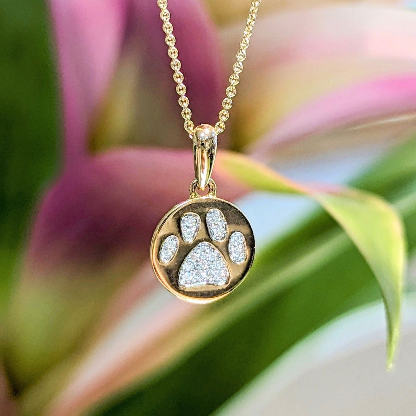 Photo of Puppy Paw Diamond Necklace in a decorative scene, designed by , available at Plumb Gold & Plumb Silver