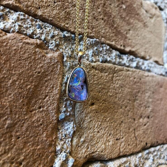 Photo of Purple Boulder Opal Pendant in a decorative scene, designed by , available at Plumb Gold & Plumb Silver