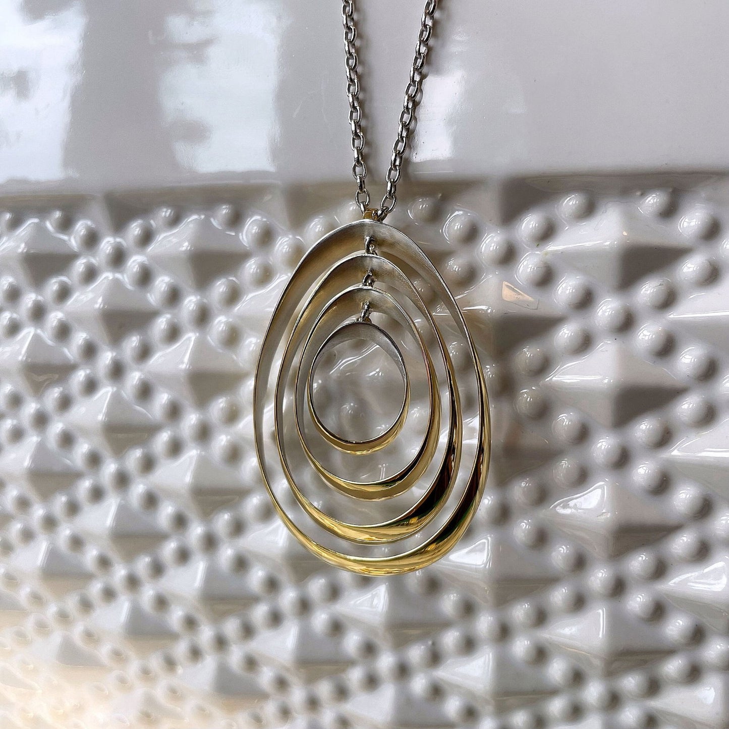 Photo of “Quadruple Bubble” Pendant in a decorative scene, designed by , available at Plumb Gold & Plumb Silver