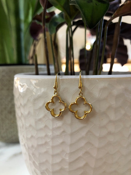 Photo of Quatrefoil Dangle Earrings in a decorative scene, designed by , available at Plumb Gold & Plumb Silver