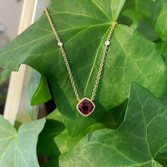 Photo of Red Garnet and Diamond Necklace in a decorative scene, designed by , available at Plumb Gold & Plumb Silver