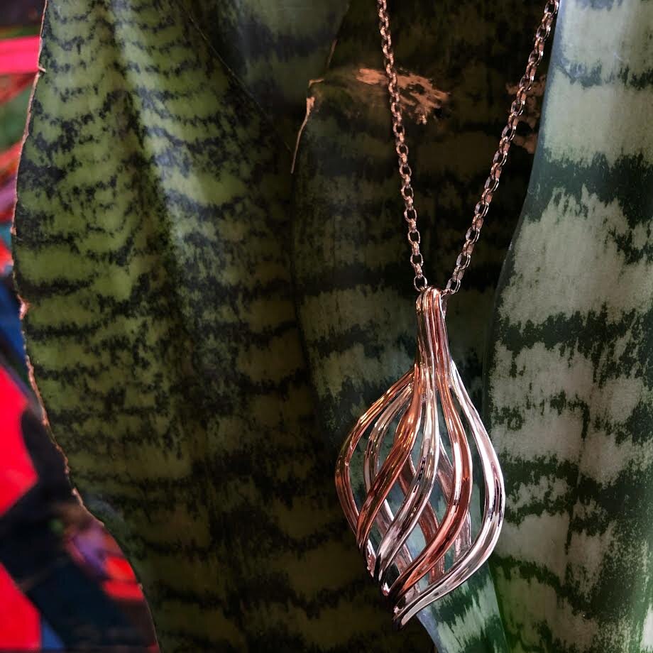 Photo of "Rivers" Pendant in a decorative scene, designed by , available at Plumb Gold & Plumb Silver