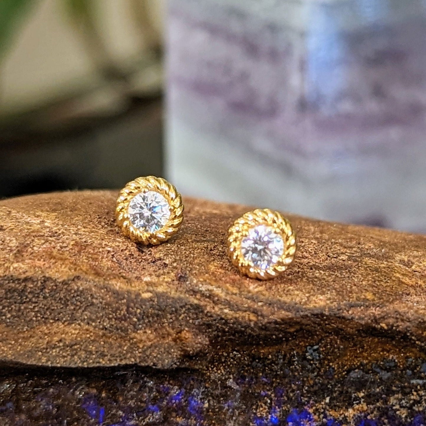 Photo of Rope Bezel CZ Studs in a decorative scene, designed by , available at Plumb Gold & Plumb Silver