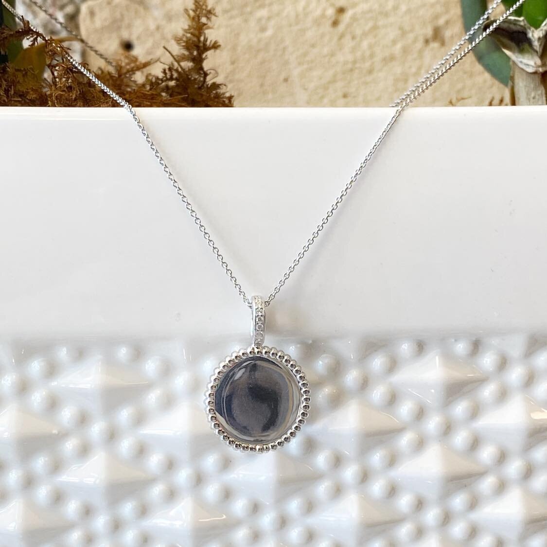 Photo of Rope Bezel Disc Necklace in a decorative scene, designed by , available at Plumb Gold & Plumb Silver