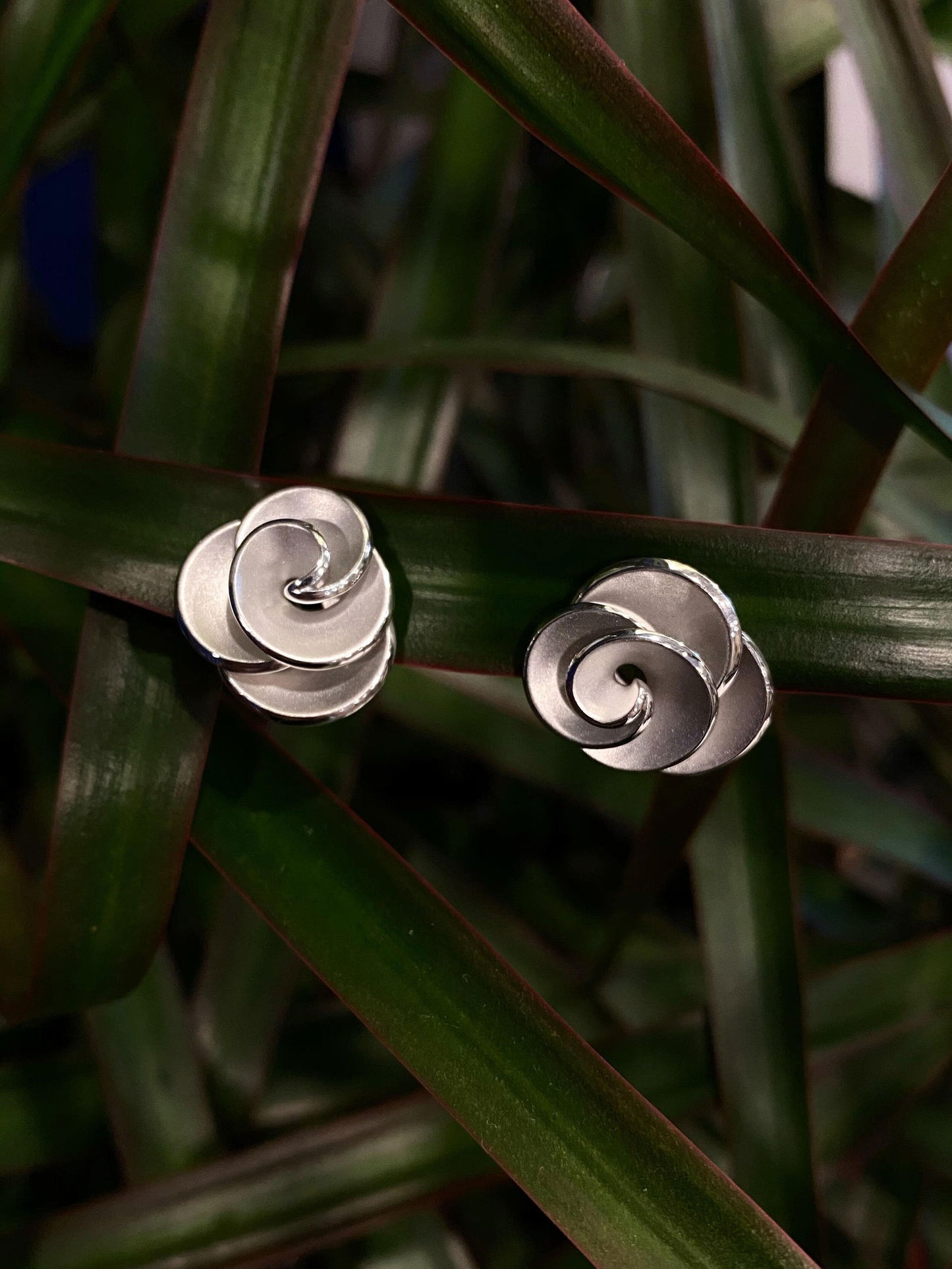 Photo of Rosette Omega Earrings in a decorative scene, designed by , available at Plumb Gold & Plumb Silver