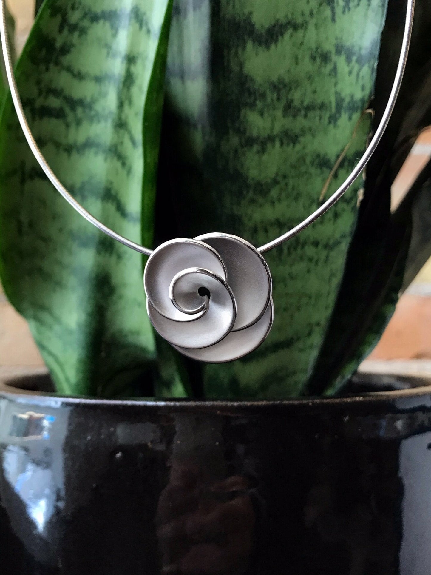 Photo of Rosette Pendant in a decorative scene, designed by , available at Plumb Gold & Plumb Silver