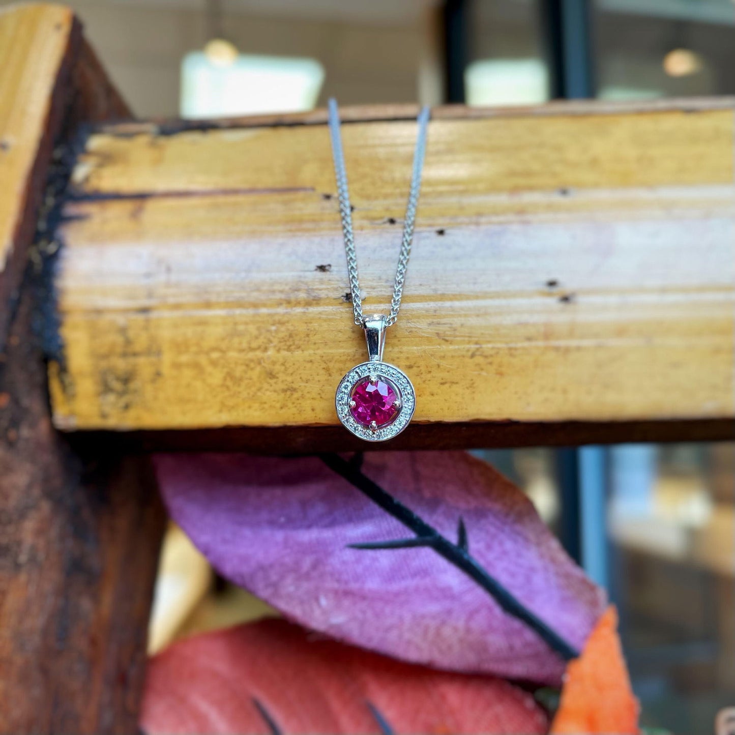 Photo of Ruby Diamond Pendant in a decorative scene, designed by , available at Plumb Gold & Plumb Silver