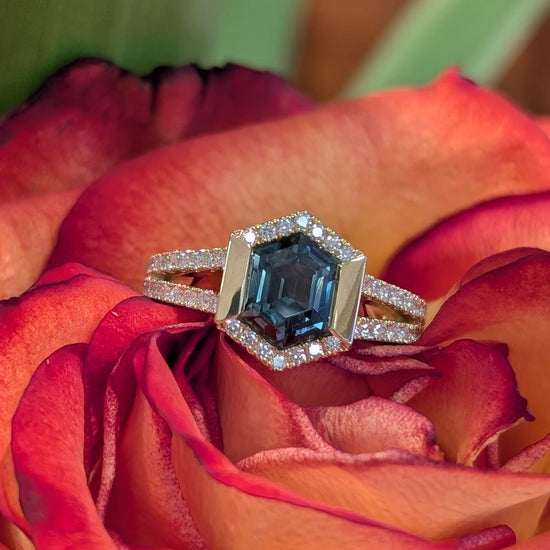 Photo of Sapphire Hexagon Halo Ring in a decorative scene, designed by , available at Plumb Gold & Plumb Silver