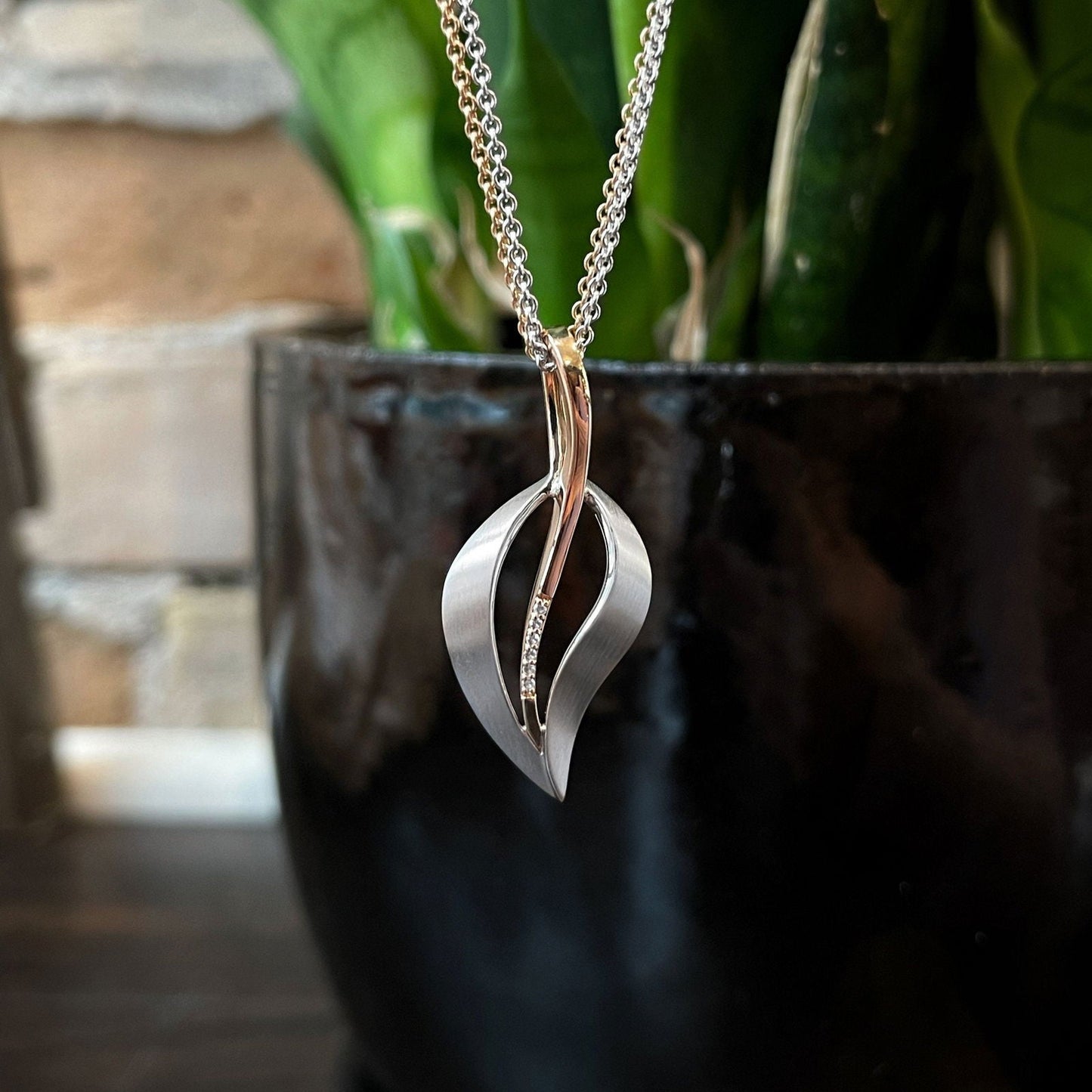 Photo of Satin Leaf Pendant in a decorative scene, designed by , available at Plumb Gold & Plumb Silver