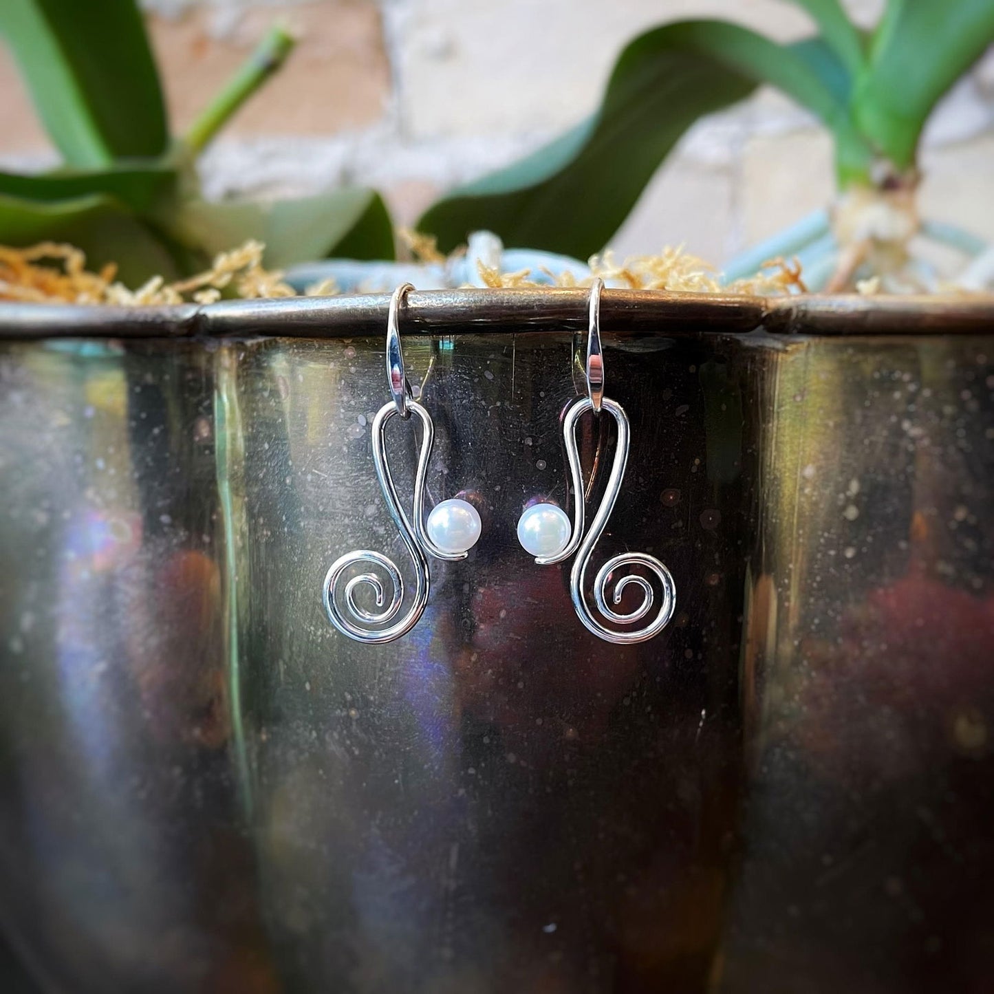 Photo of "Script" Pearl Earrings in a decorative scene, designed by , available at Plumb Gold & Plumb Silver