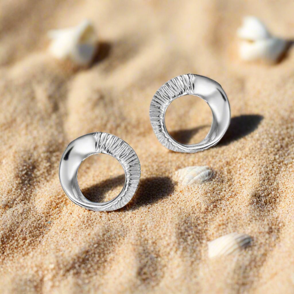 Photo of Seaweed stud earrings in a decorative scene, designed by -, available at Plumb Gold & Plumb Silver