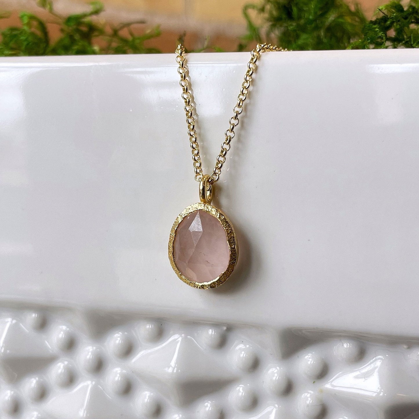 Photo of “Shade” Rose Quartz Pendant in a decorative scene, designed by , available at Plumb Gold & Plumb Silver