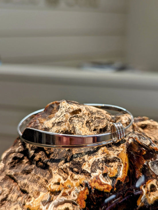 Photo of "Slide" Bracelet in a decorative scene, designed by , available at Plumb Gold & Plumb Silver