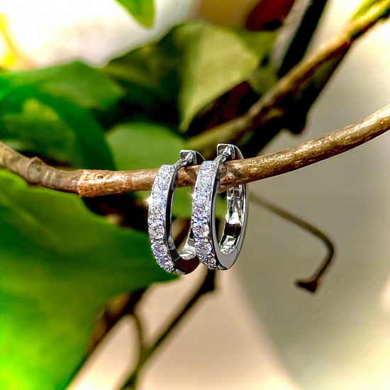 Photo of Small Diamond Huggies in a decorative scene, designed by , available at Plumb Gold & Plumb Silver
