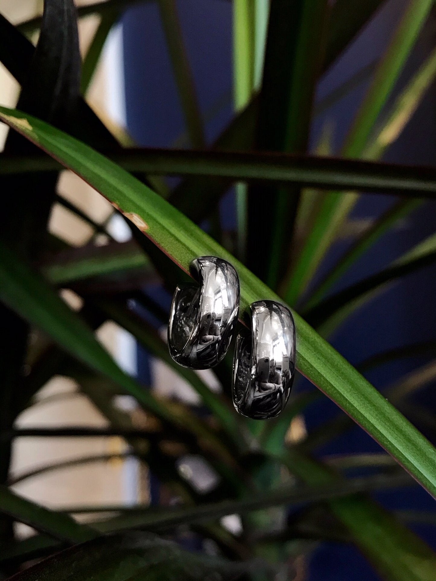 Photo of Small Hinged Hoop Earrings in a decorative scene, designed by , available at Plumb Gold & Plumb Silver