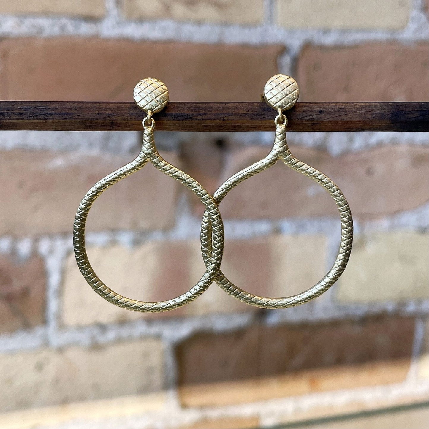 Photo of “Snakeskin” Dangles in a decorative scene, designed by , available at Plumb Gold & Plumb Silver