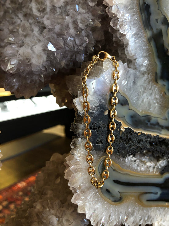 Photo of Solid Oval Fancy Link Bracelet in a decorative scene, designed by , available at Plumb Gold & Plumb Silver