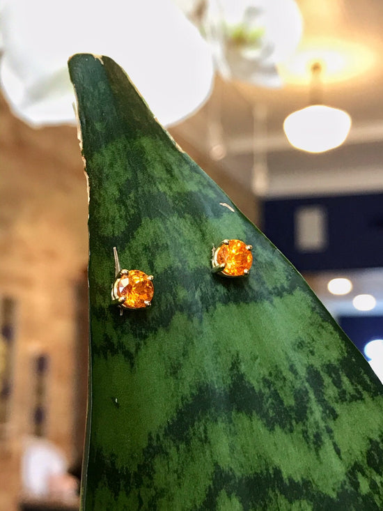 Photo of Spessartite Garnet Studs in a decorative scene, designed by , available at Plumb Gold & Plumb Silver