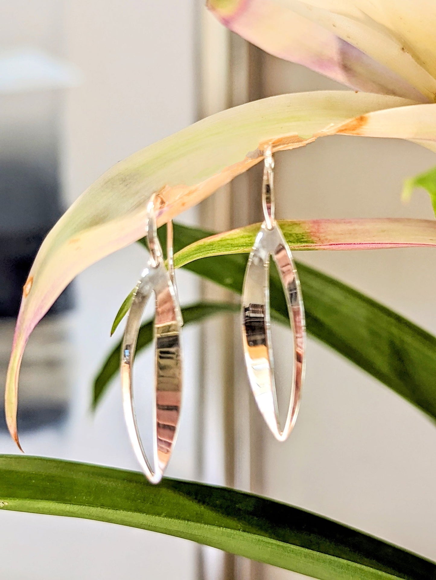 Photo of "Spinner" Earring in a decorative scene, designed by , available at Plumb Gold & Plumb Silver