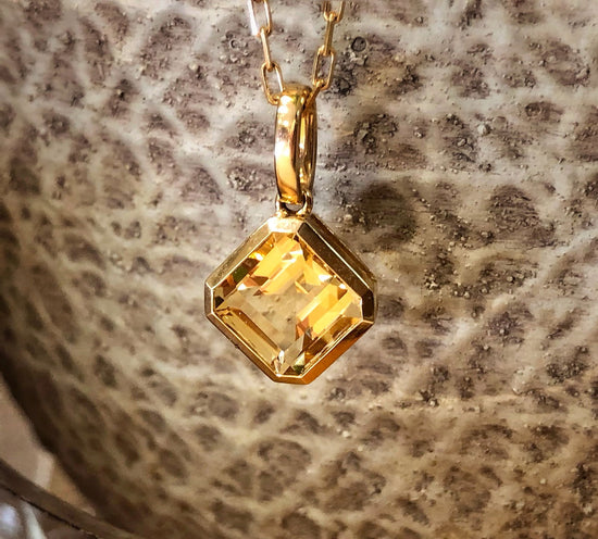 Photo of Square Gemstone Pendant in a decorative scene, designed by , available at Plumb Gold & Plumb Silver