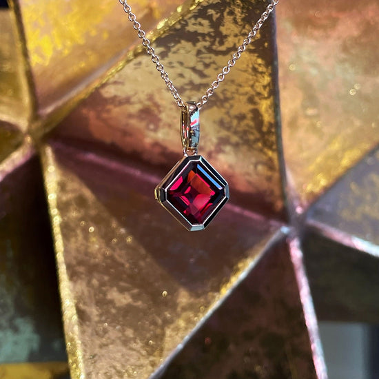Photo of Square Gemstone Pendant in a decorative scene, designed by , available at Plumb Gold & Plumb Silver