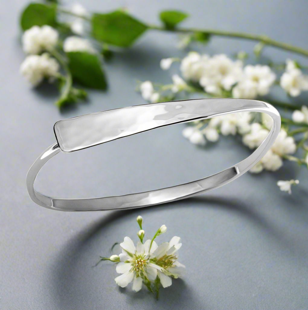 Photo of "Squircle Flip" Bracelet in a decorative scene, designed by , available at Plumb Gold & Plumb Silver