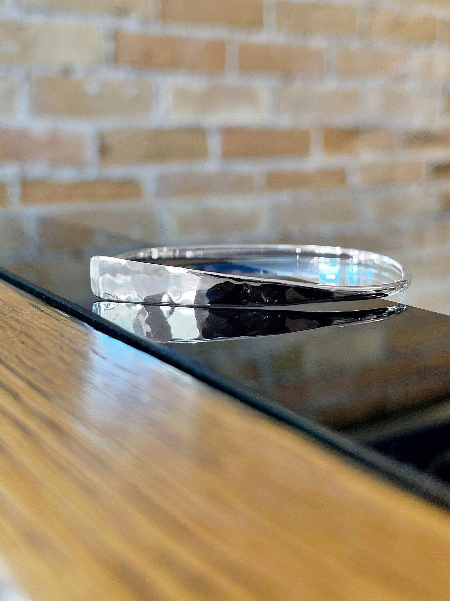 Photo of "Squircle Flip" Bracelet in a decorative scene, designed by , available at Plumb Gold & Plumb Silver
