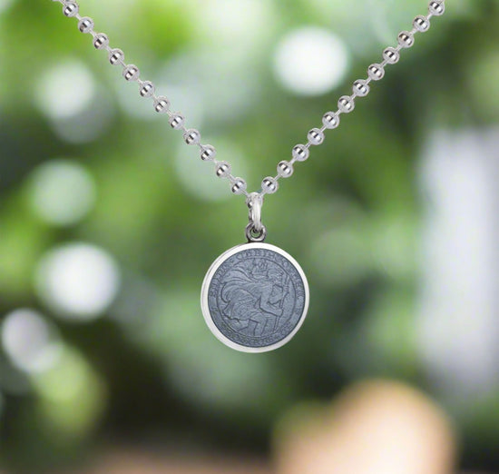 Photo of St. Christopher Pendant in a decorative scene, designed by , available at Plumb Gold & Plumb Silver