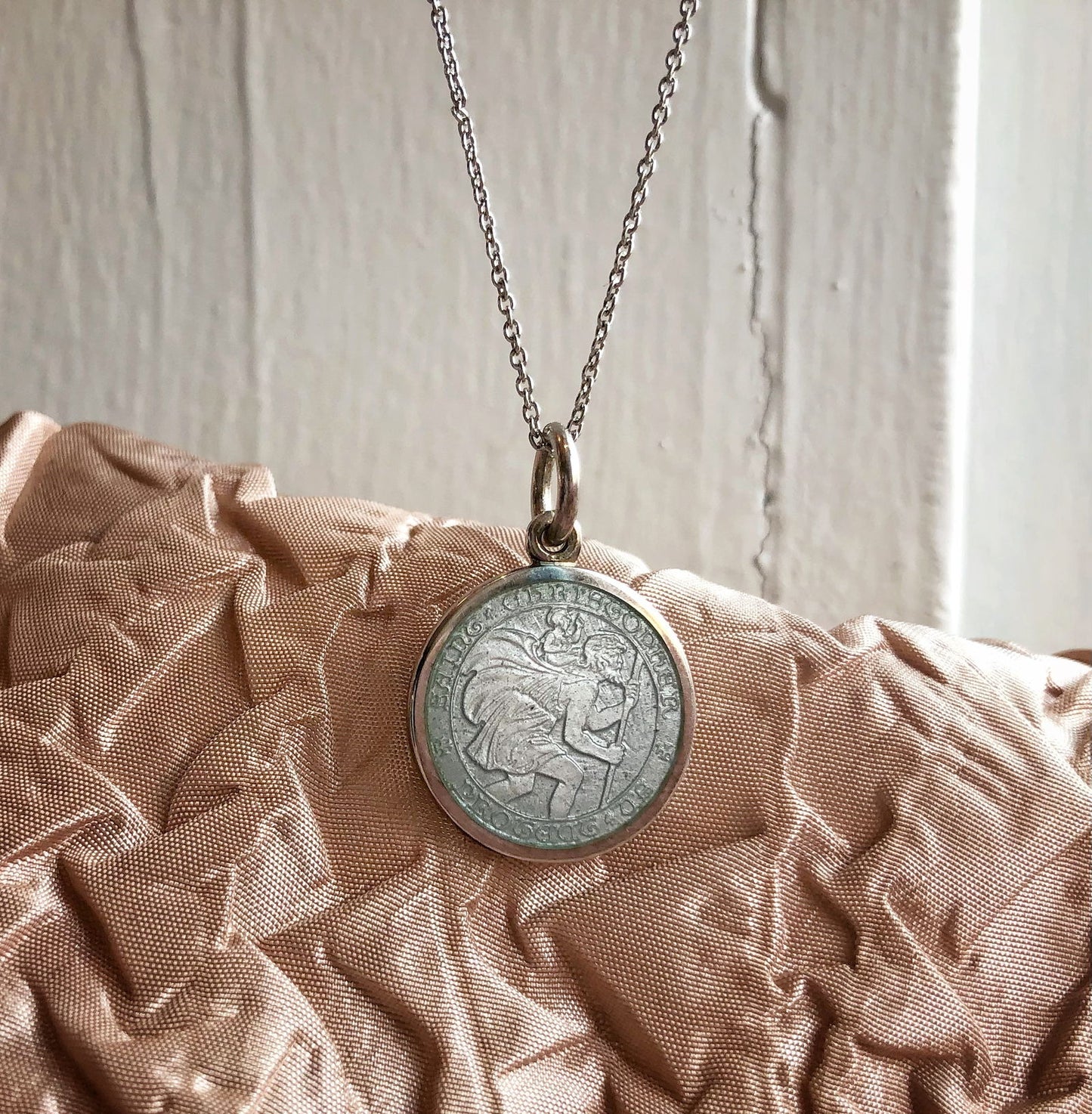 Photo of St. Christopher Pendant in a decorative scene, designed by , available at Plumb Gold & Plumb Silver