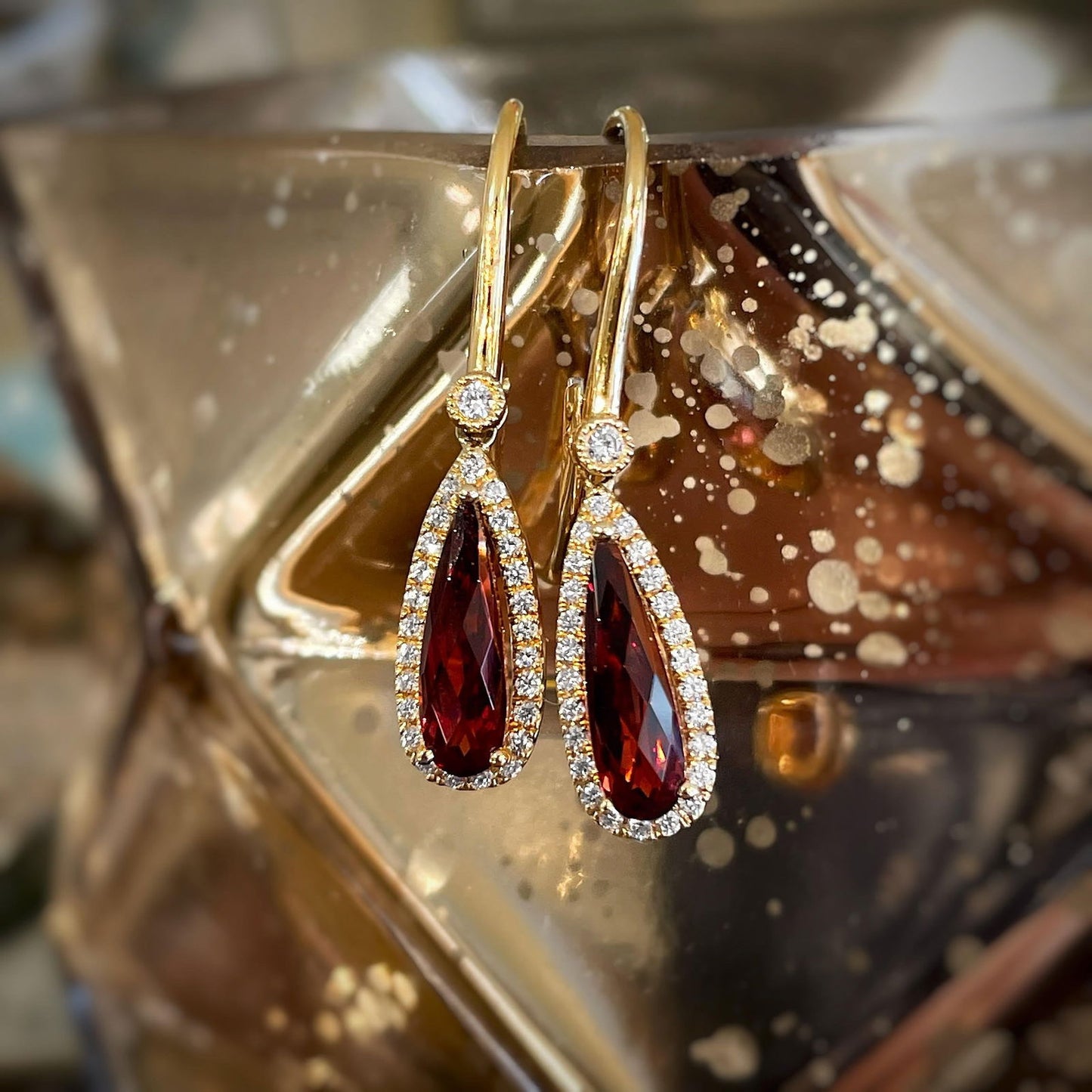 Photo of Stanton Color Garnet and Diamond Dangles in a decorative scene, designed by , available at Plumb Gold & Plumb Silver