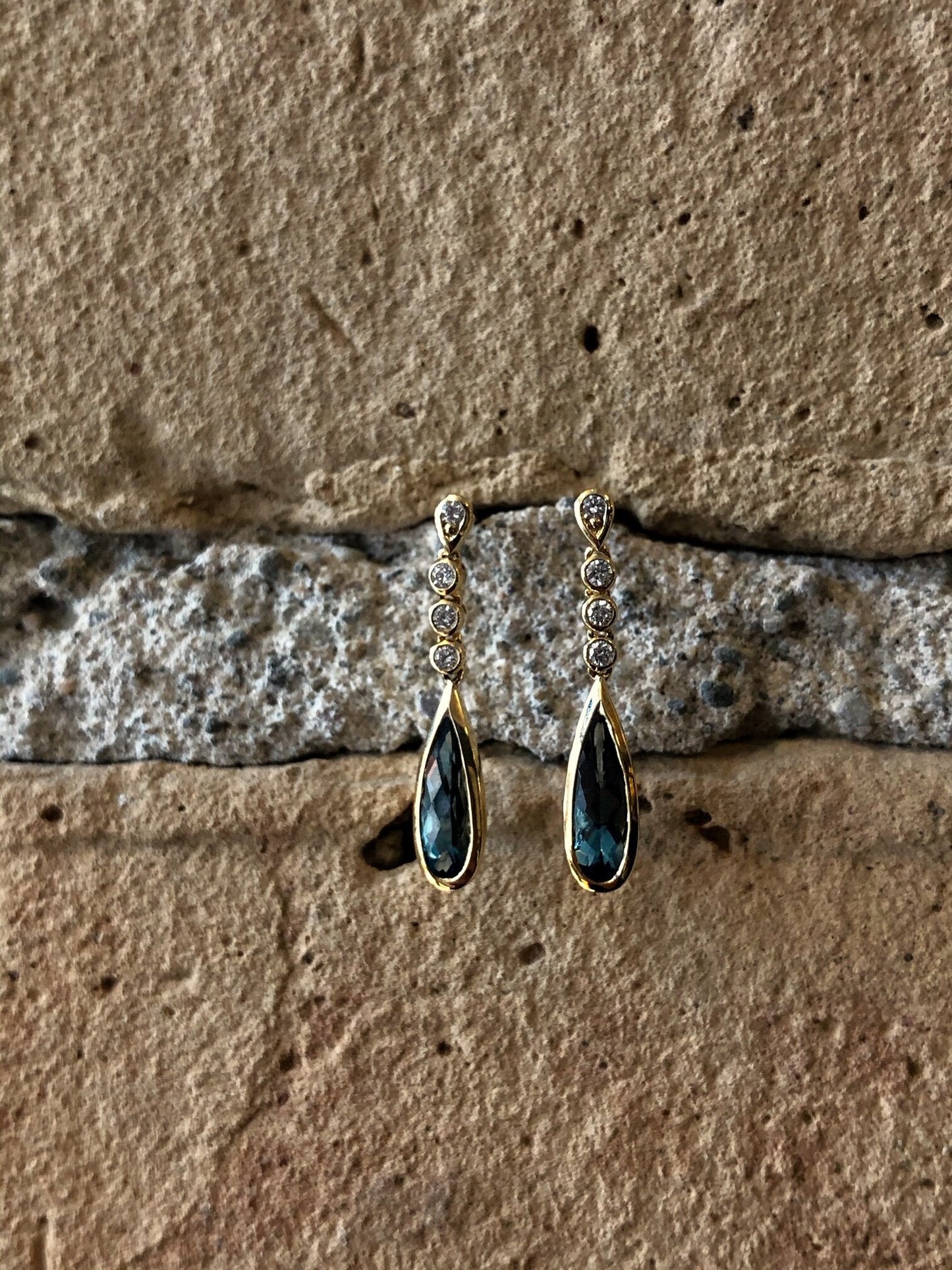 Photo of Stanton Color London Blue Topaz and Diamond Dangles in a decorative scene, designed by , available at Plumb Gold & Plumb Silver