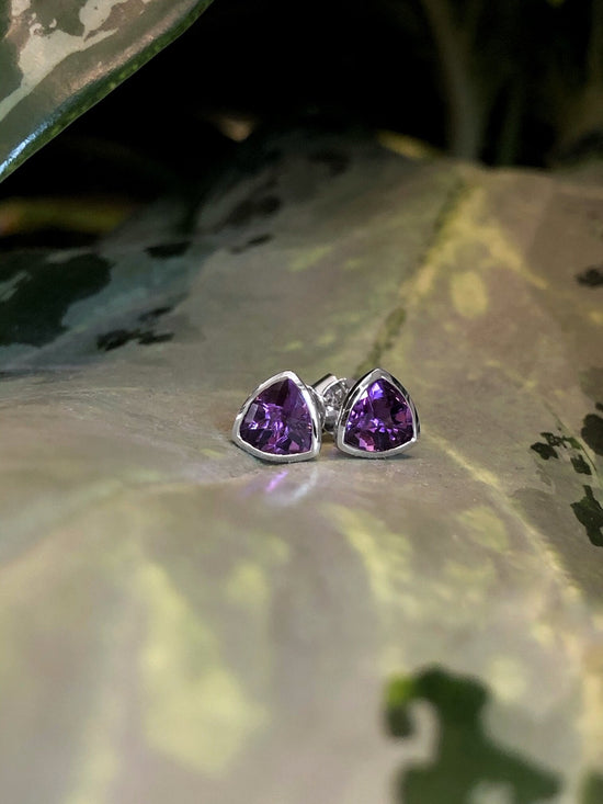 Photo of Stanton Color Trillion Amethyst Studs in a decorative scene, designed by , available at Plumb Gold & Plumb Silver