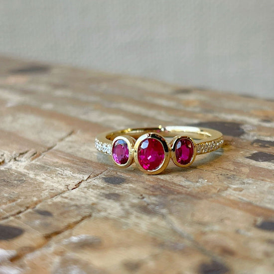 Photo of Stanton Color Triple Ruby Ring in a decorative scene, designed by , available at Plumb Gold & Plumb Silver